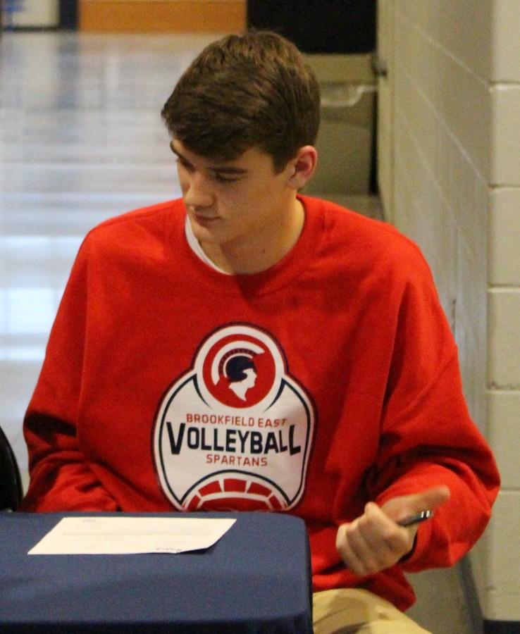 Matt Szews (12) prepares to sign letter of intent to play volleyball at Ball State next year.