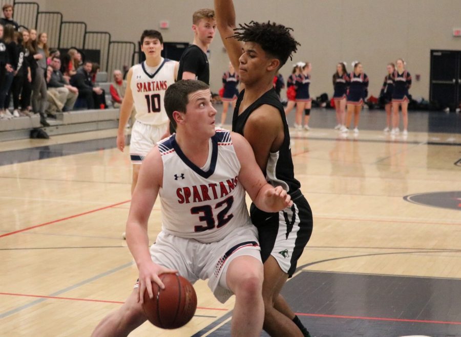 Riley LeTourneau (12) fends off a Hale defender to take a shot 